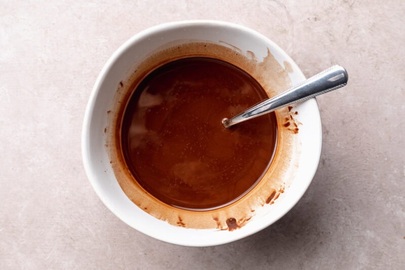 Melted chocolate and coconut oil in a microwave-safe mixing bowl.