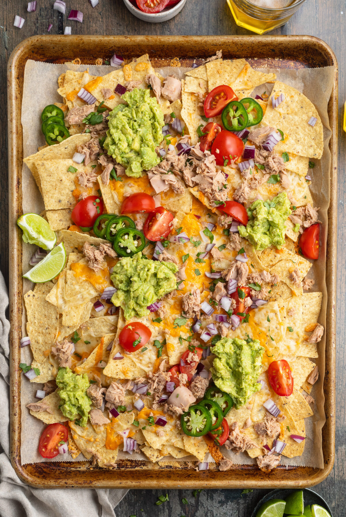 Overhead view of a large sheet pan covered with tuna nachos.