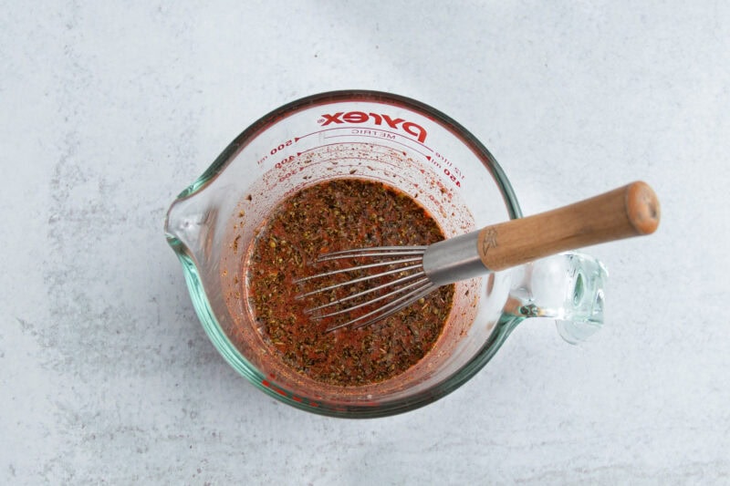Achiote chicken sauce in glass measuring cup.