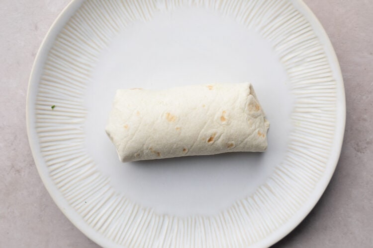 Carnitas burrito on a white plate.
