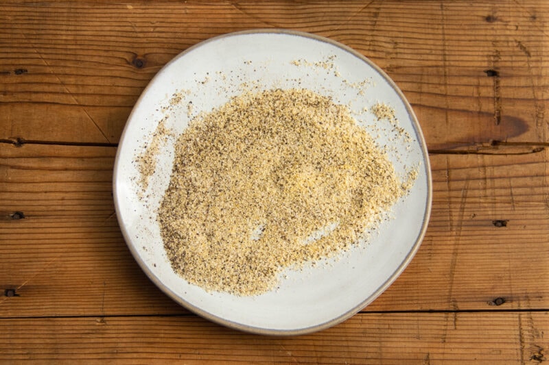 Salt, garlic powder, and pepper blend on a shallow plate.