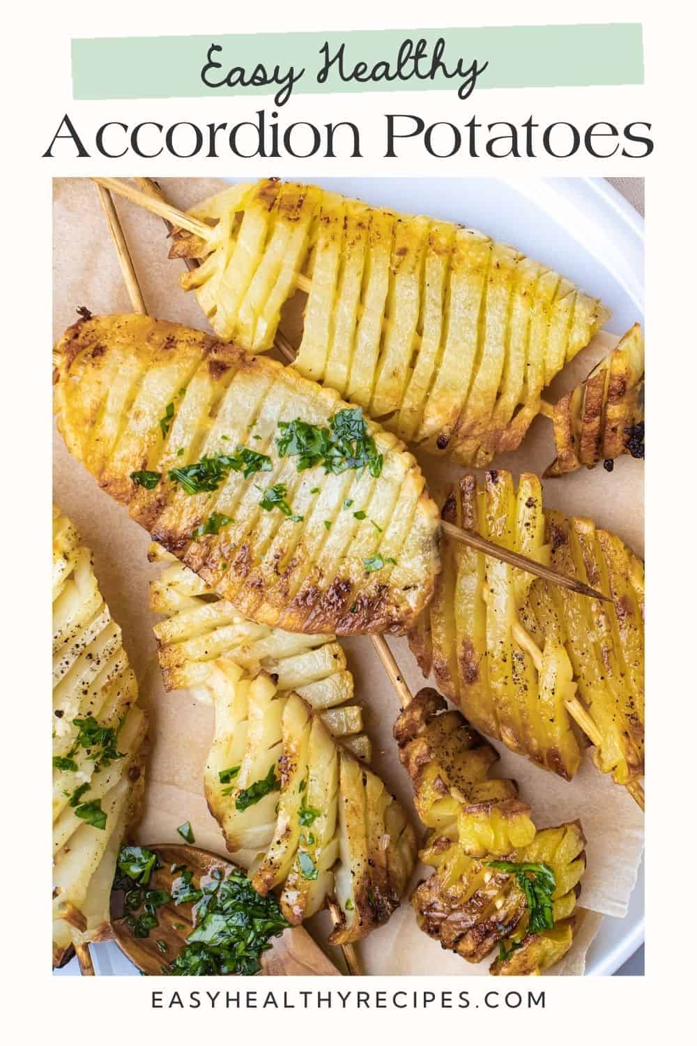 Close up of accordion potatoes brushed with fresh herb marinade. There is a white frame and a Pinterest-optimised text overlay.