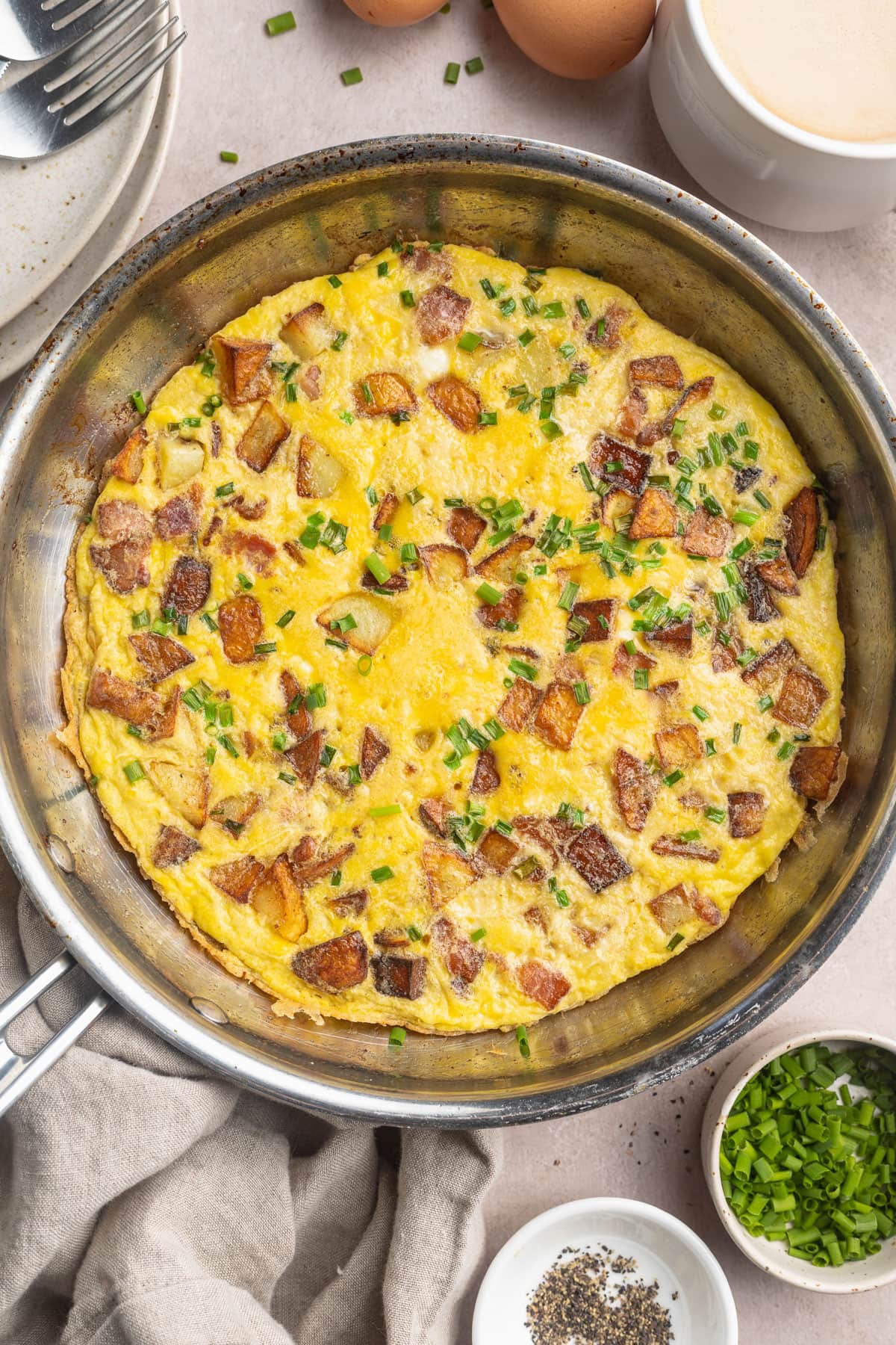 A large country omelette in a large silver skillet.