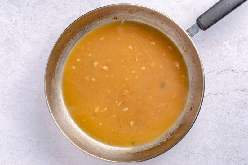 Salmon piccata sauce in a large silver skillet.