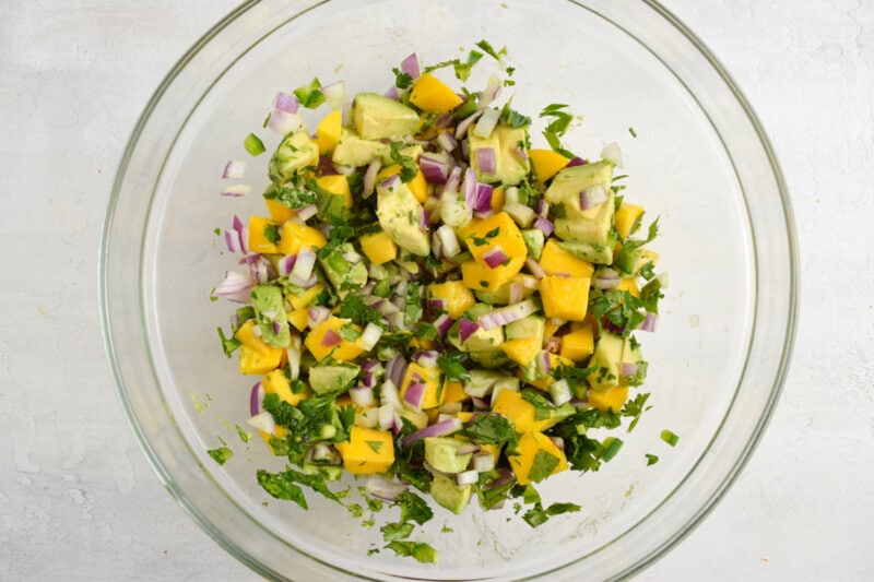 Avocado mango salsa in a glass mixing bowl.