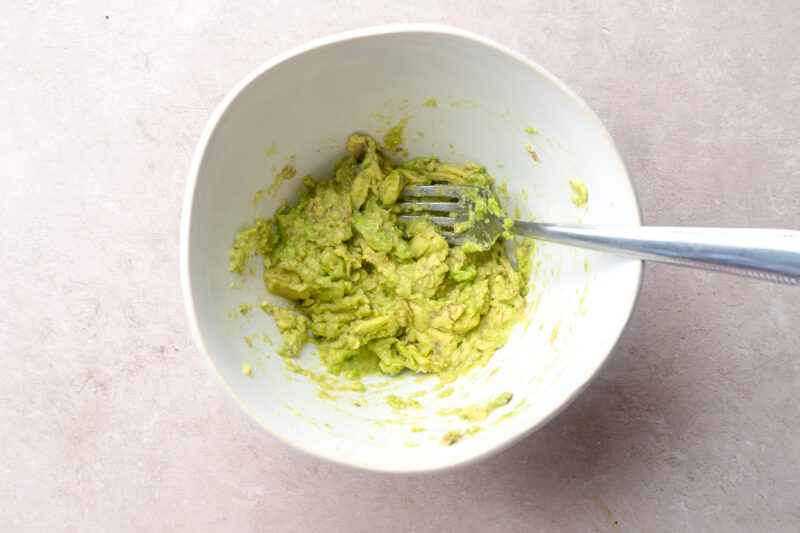 Guacamole in a small bowl with a fork.