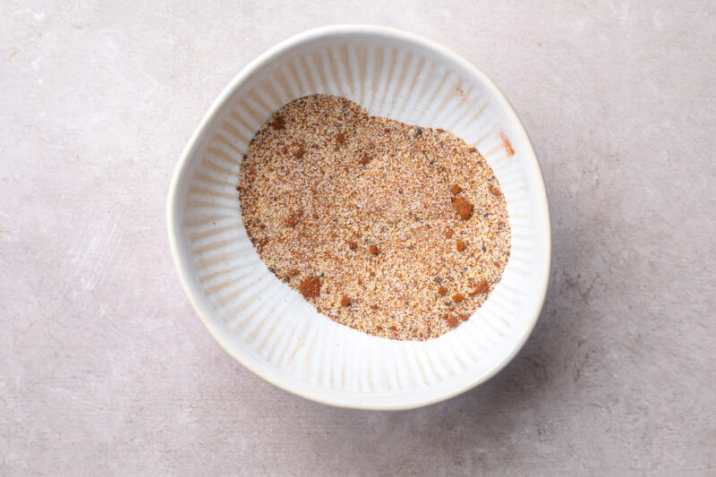 Spice blend for whole chicken wings in a white bowl.