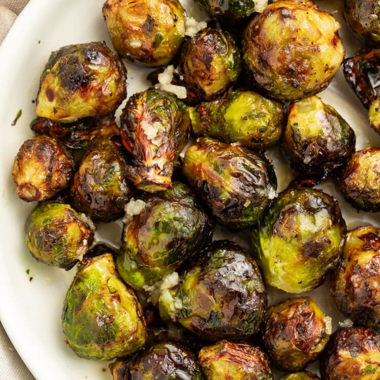 Air fryer frozen brussels sprouts on a large white plate.