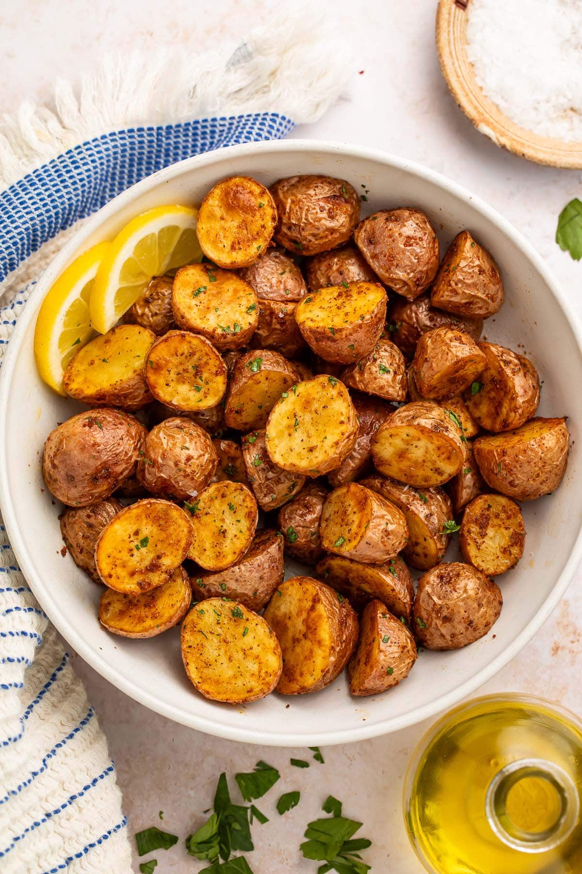 A bowl of air fryer red potatoes with 2 lemon slices.