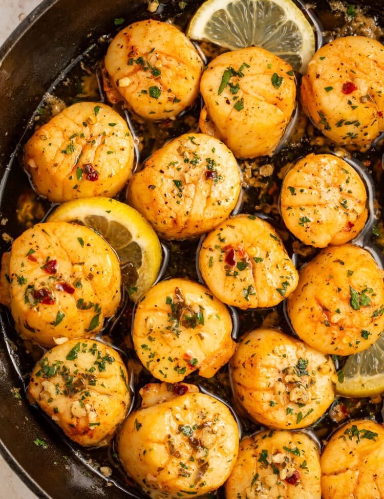 Scallops with a lemon, garlic and herb butter in a cast iron skillet.