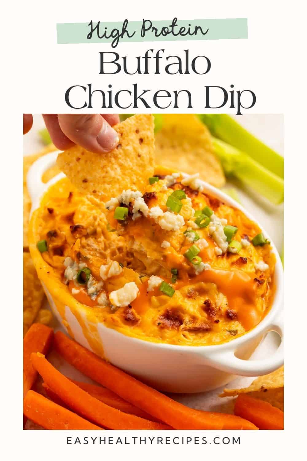 Hand dipping a tortilla chip into a baked buffalo dip on a Pinterest pin layout.