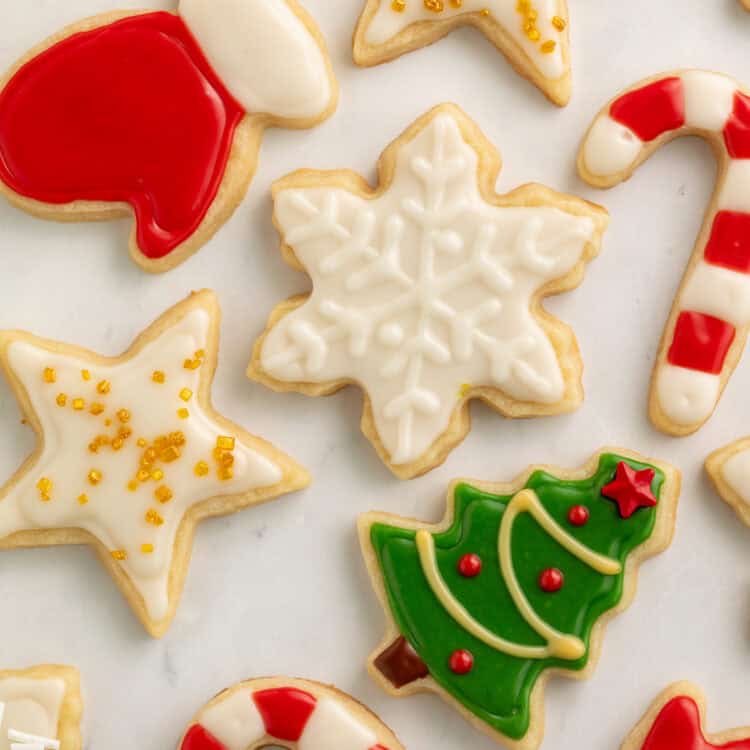 Christmas cookies decorated as a star, a snowflake, a tree, candy canes, gloves and a pair of mittens.