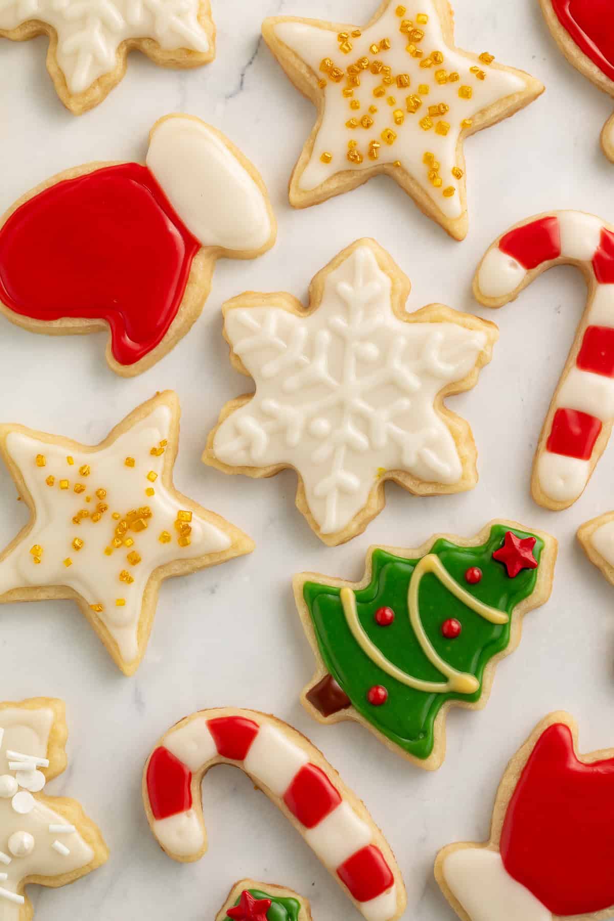Christmas cookies decorated as a star, a snowflake, a tree, candy canes, gloves and a pair of mittens.