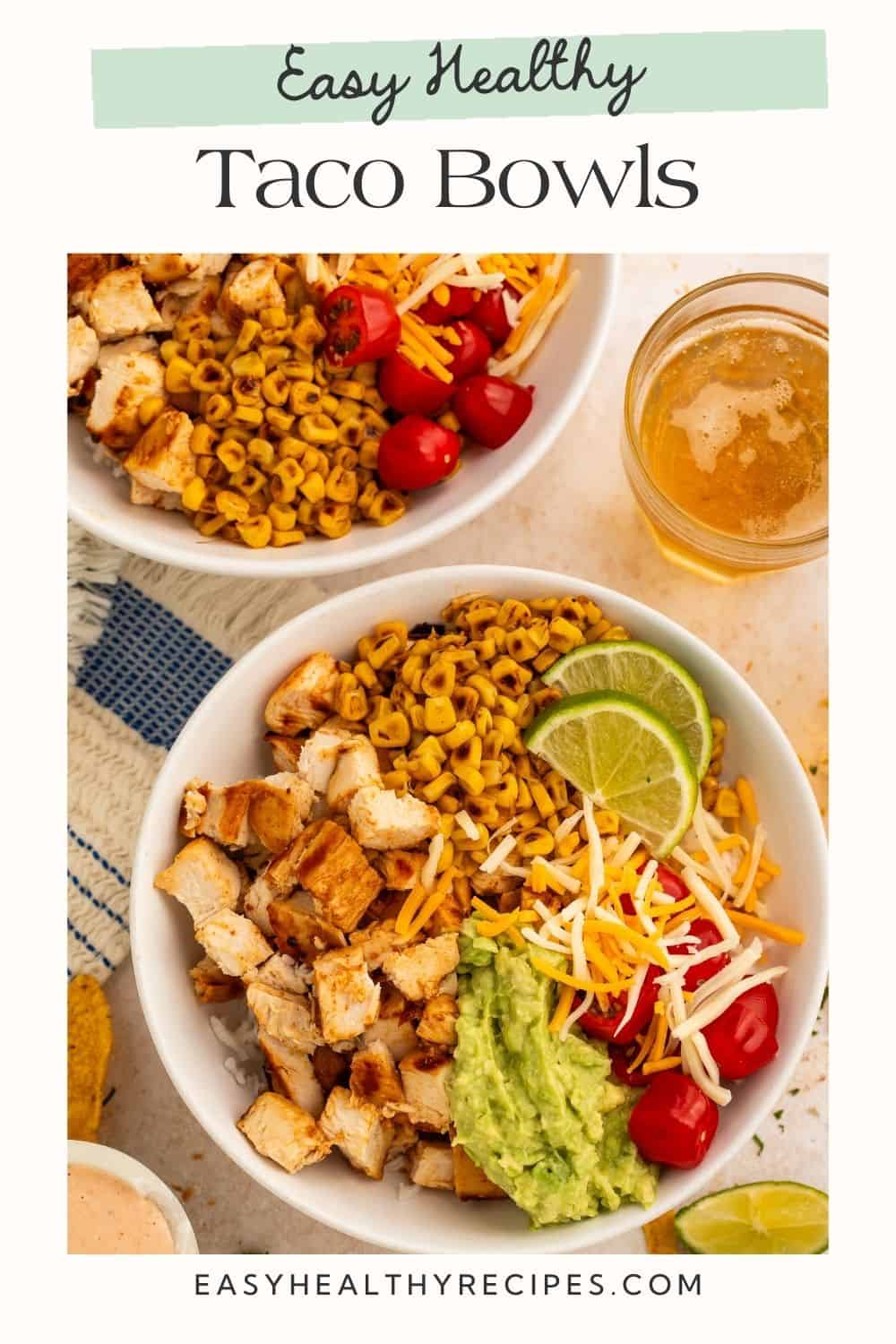 Close up of two healthy taco bowls with a glass of beer to one side. There is a Pinterest-optimised text overlay.