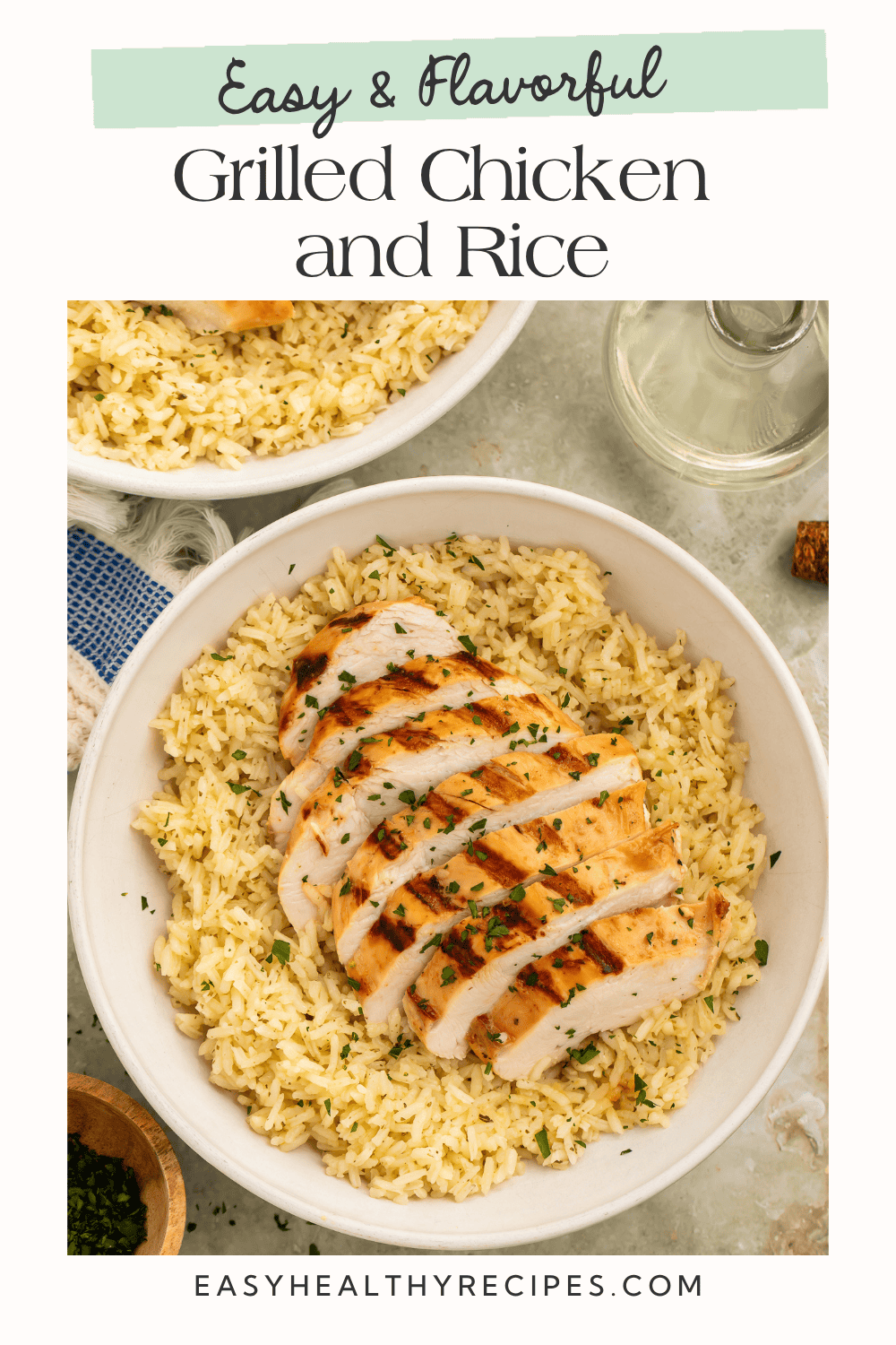 Overhead view of sliced grilled chicken breast over seasoned rice in a white bowl with a second bowl in background