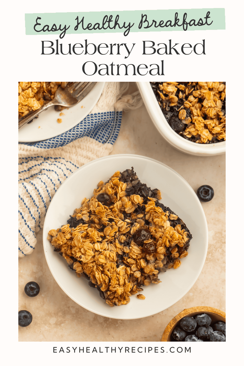 Overhead view of a slice of blueberry baked oatmeal on a white plate with a baking dish and fresh blueberries nearby