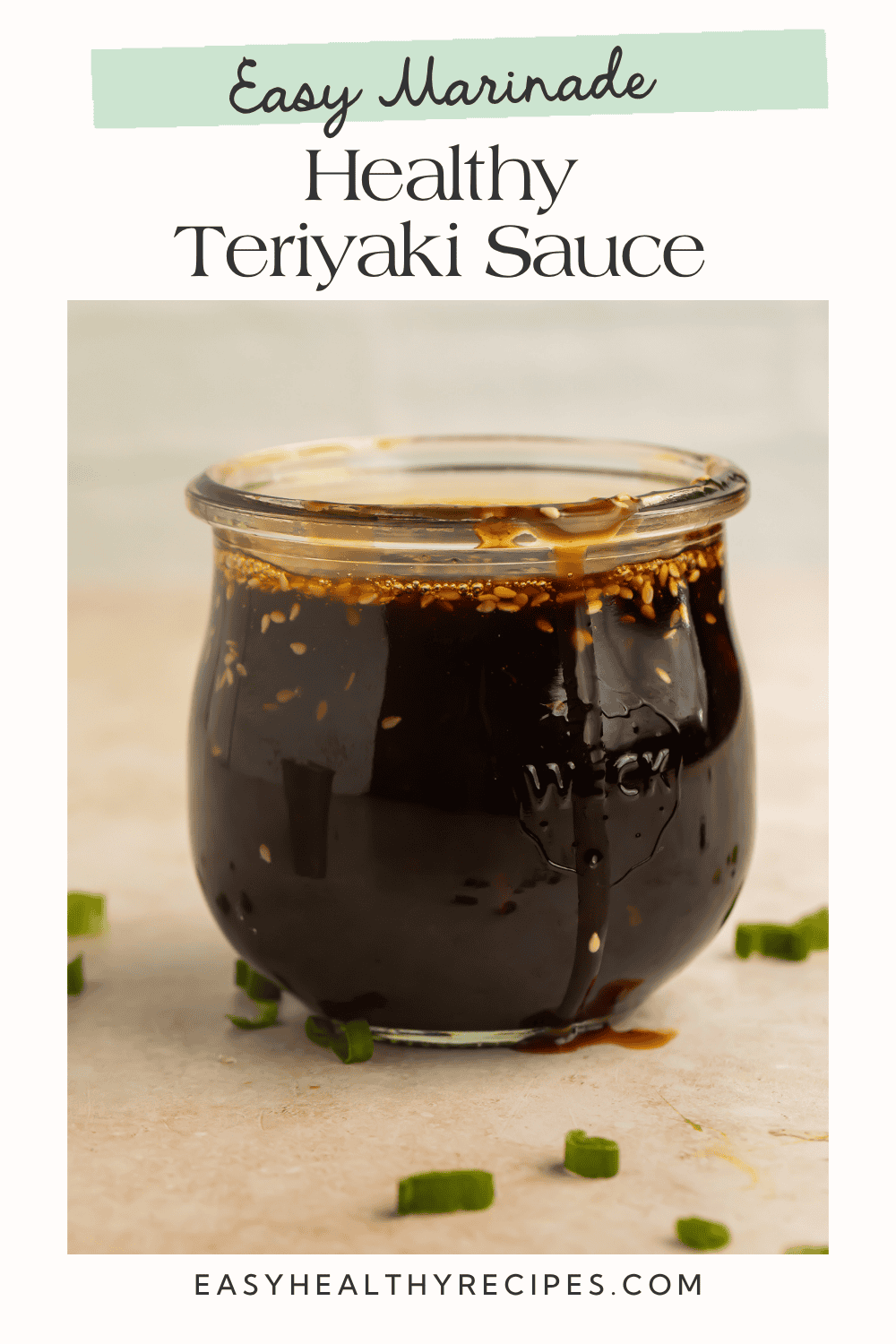 Healthy homemade teriyaki sauce in a glass jar with sesame seeds and green onions