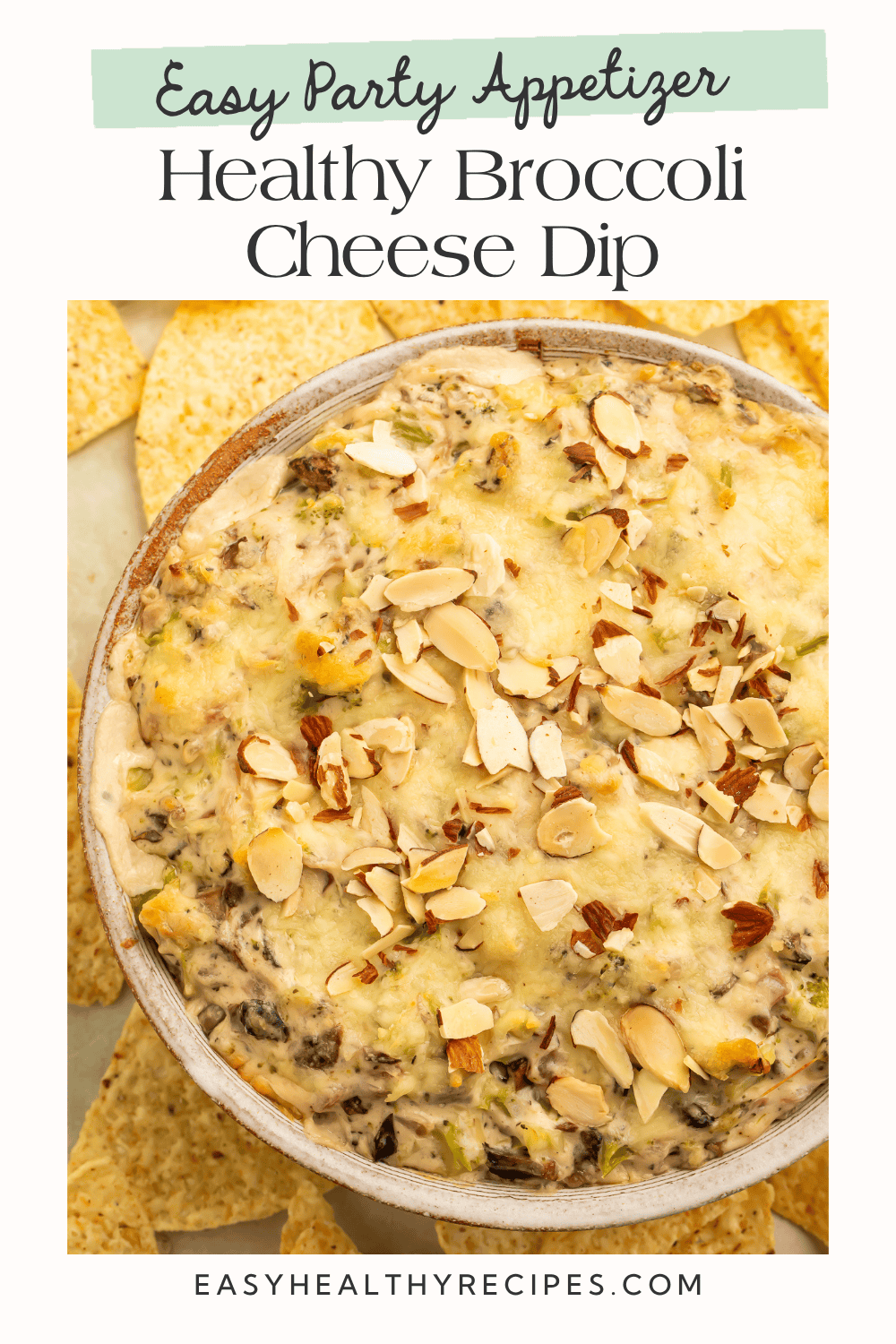 Overhead view of baked healthy broccoli cheese dip topped with melted mozzarella and toasted sliced almonds, surrounded by tortilla chips