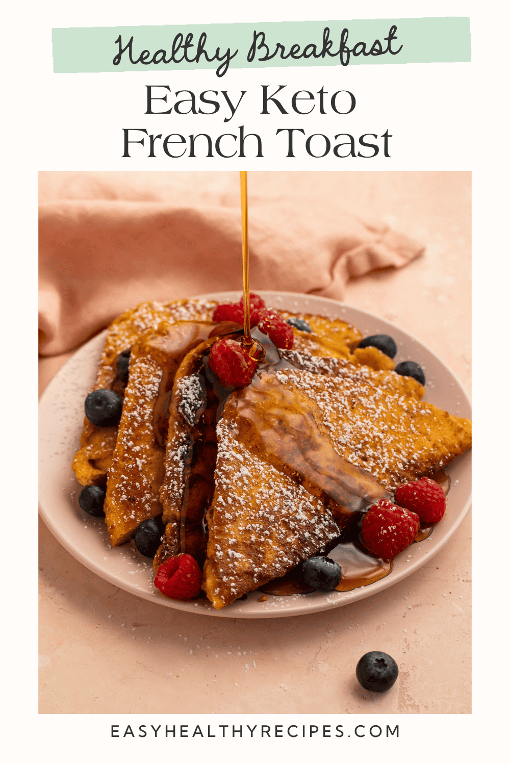 Easy keto French toast drizzled with sugar-free maple syrup and topped with fresh raspberries and blueberries.