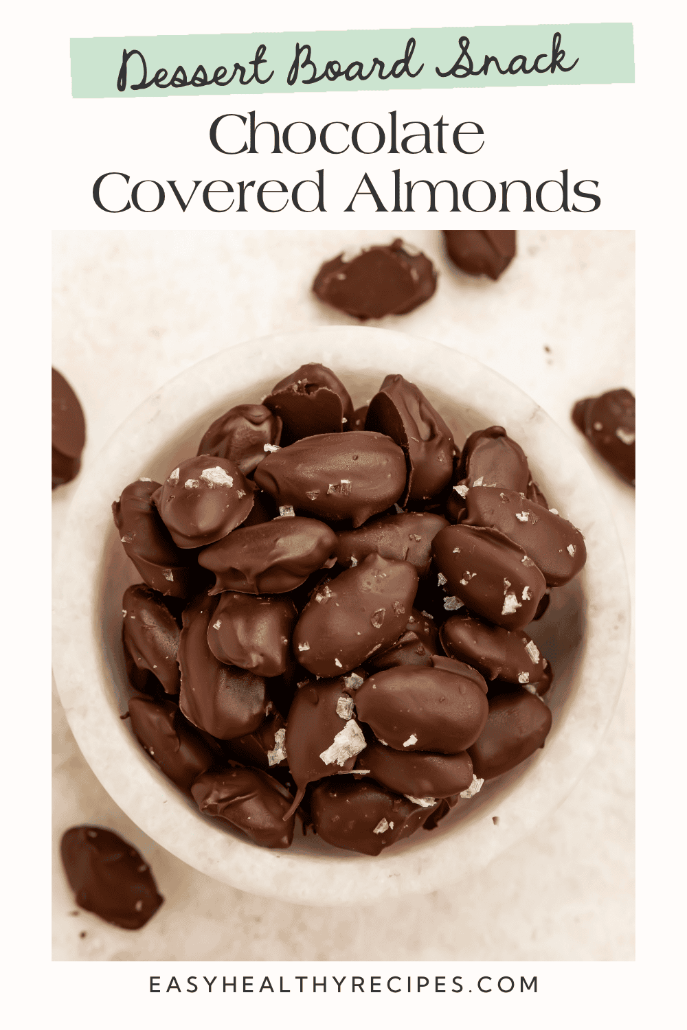 Dessert board snack graphic featuring homemade dark chocolate-covered almonds sprinkled with flaky sea salt.