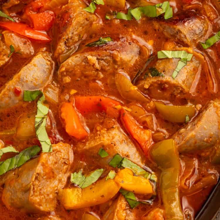 Instant Pot sausage and peppers in tomato sauce with sliced Italian sausage, bell peppers, onions, and fresh basil.