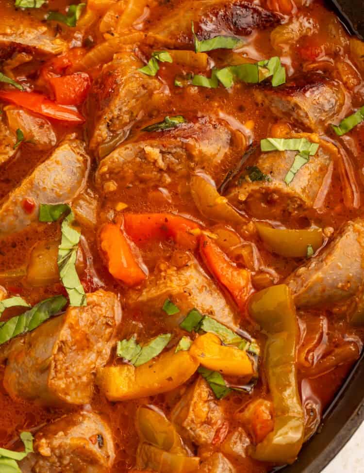 Instant Pot sausage and peppers in tomato sauce with sliced Italian sausage, bell peppers, onions, and fresh basil.
