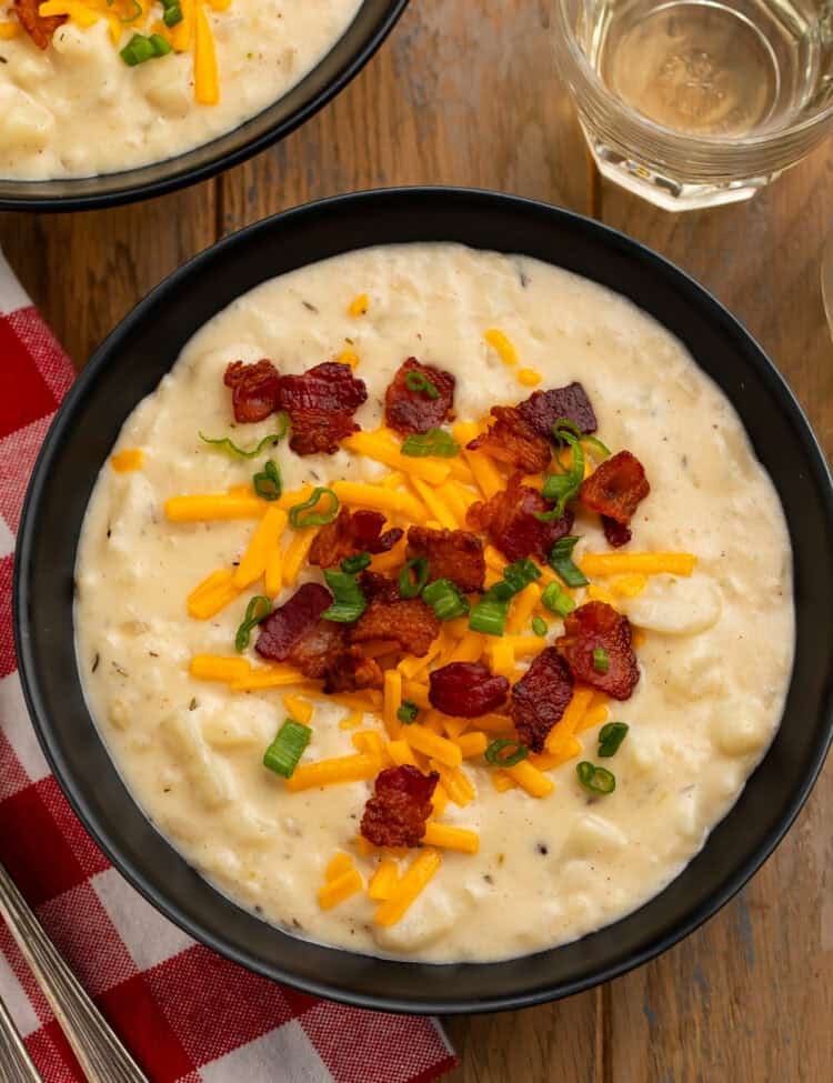 Copycat Outback Steakhouse potato soup topped with bacon, Colby Jack cheese, and green onions.