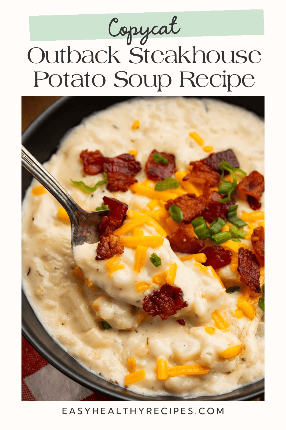 Copycat Outback Steakhouse potato soup with a spoonful of creamy soup, bacon, cheese, and green onions.