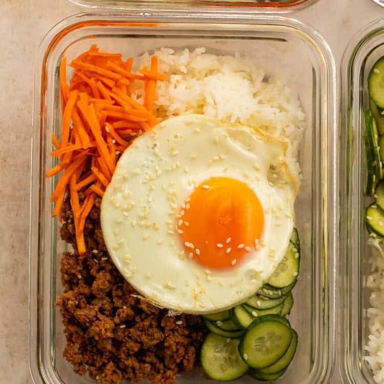 Korean ground beef bowls with rice, carrots, cucumbers, and sesame-topped fried eggs