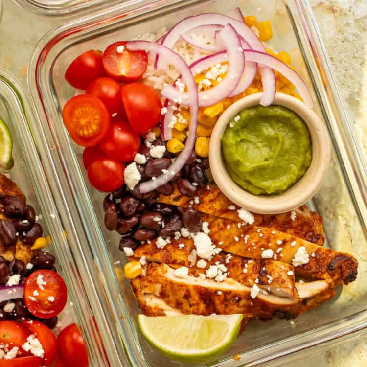 Mexican chicken bowl with sliced grilled chicken, black beans, rice, guacamole, and crumbled feta.
