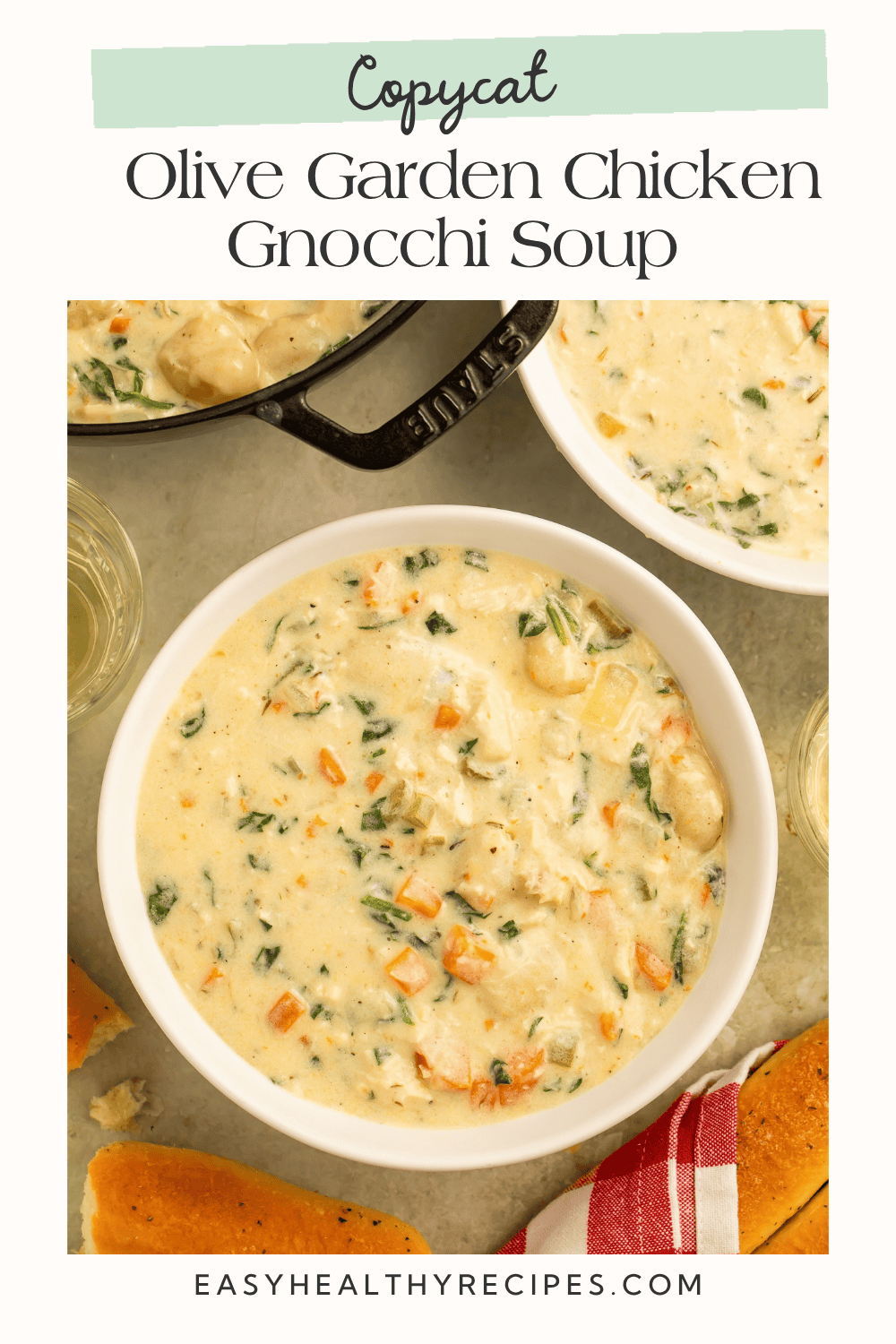 Copycat Olive Garden chicken gnocchi soup with spinach and carrots, served with breadsticks.