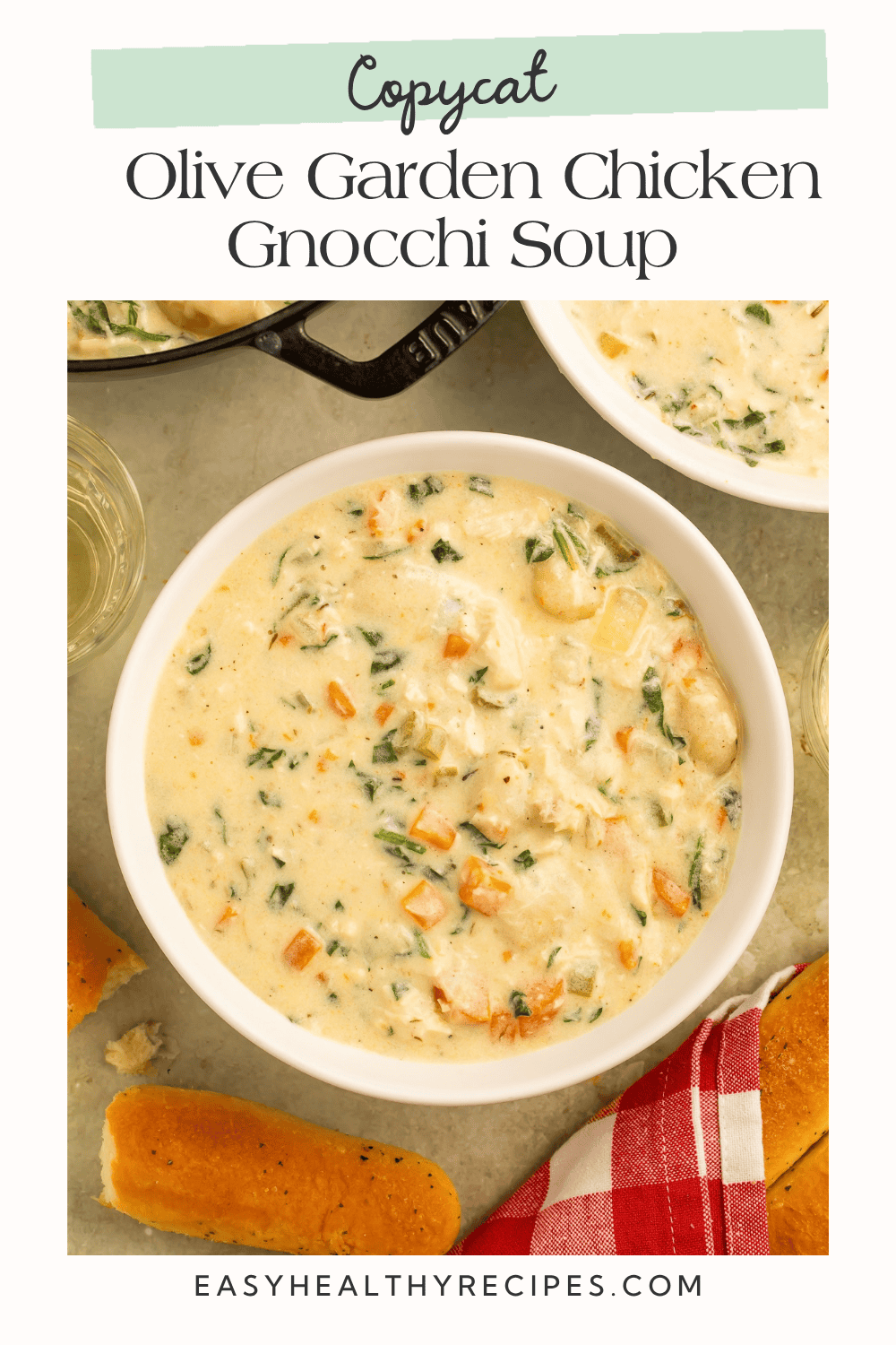 Homemade Olive Garden chicken gnocchi soup in a white bowl beside golden breadsticks.