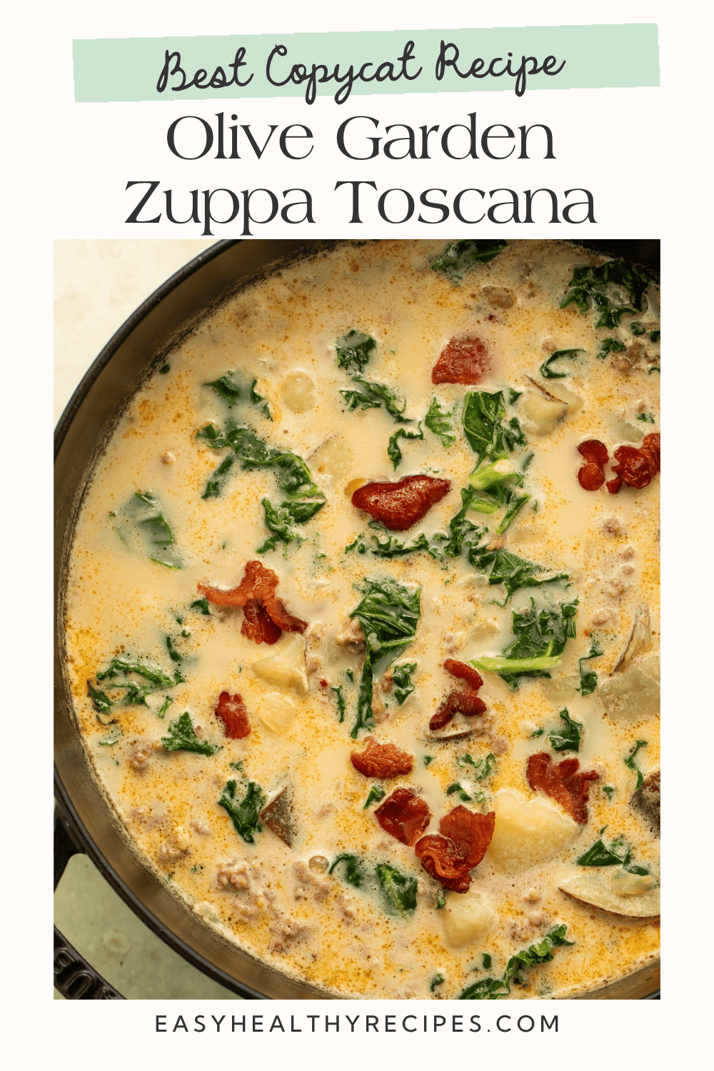 Black Dutch oven filled with Olive Garden copycat zuppa toscana, with sausage, sliced potatoes, kale, and bacon.