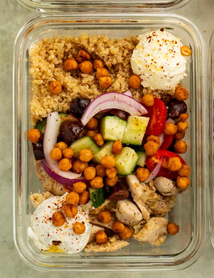 Greek chicken bowl with farro, chickpeas, cucumber, tomatoes, red onion, olives, whipped feta, and tzatziki.