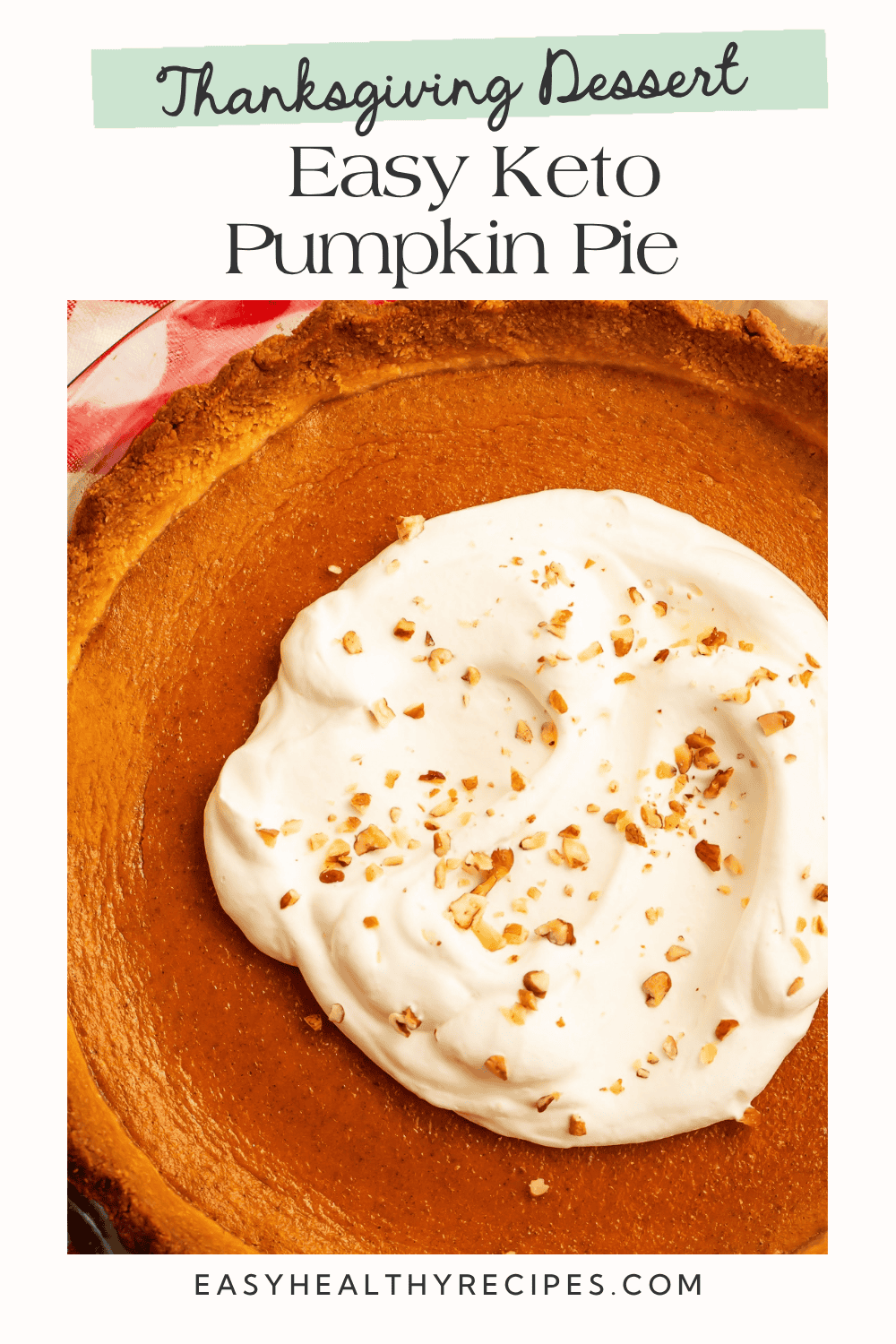 Pumpkin pie with a golden crust and a generous whipped cream topping sprinkled with chopped nuts. Text reads “Thanksgiving Dessert Easy Keto Pumpkin Pie.”