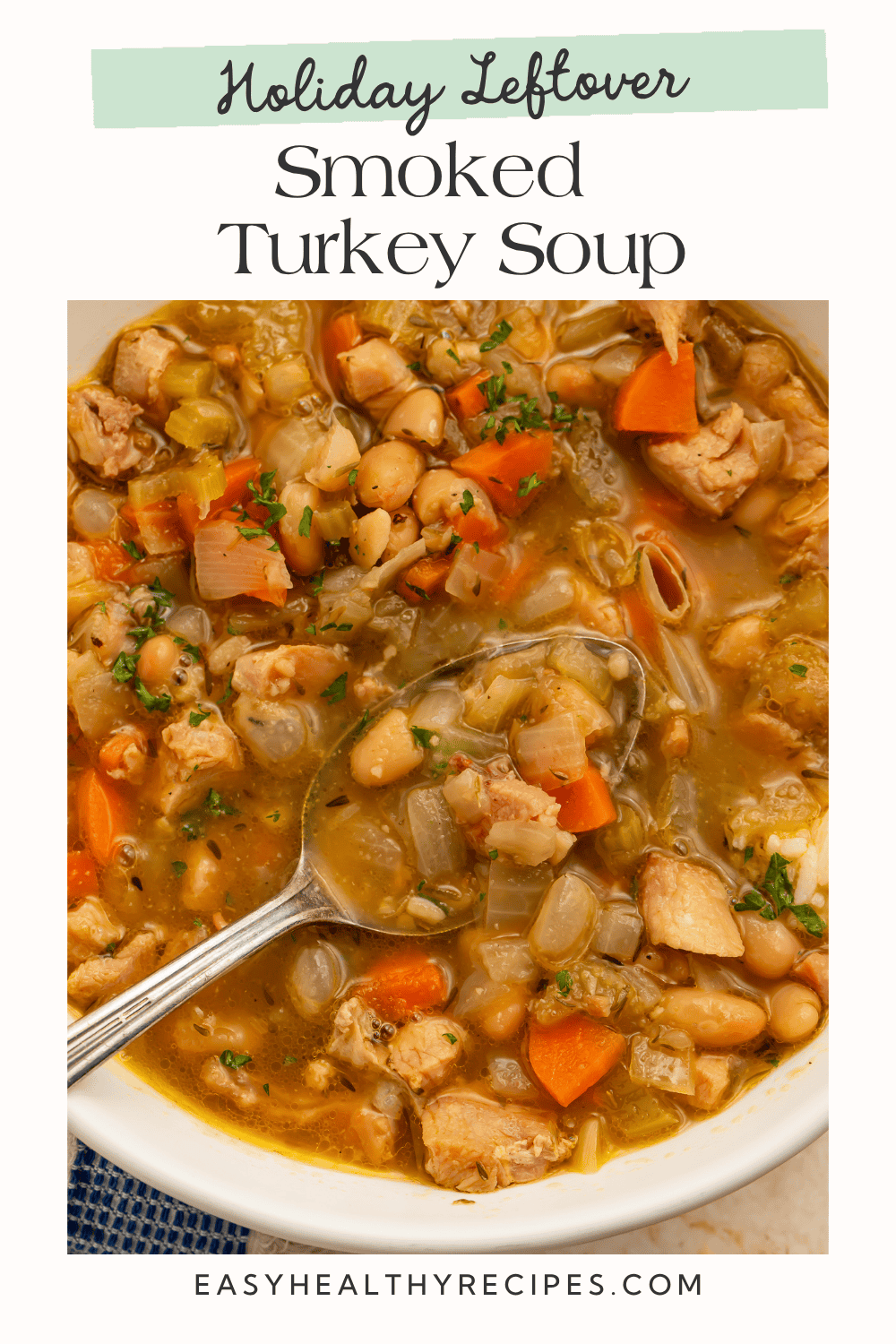 Spoon holding turkey, white beans, and vegetables in broth. Pinterest graphic reads “Holiday Leftover Smoked Turkey Soup.